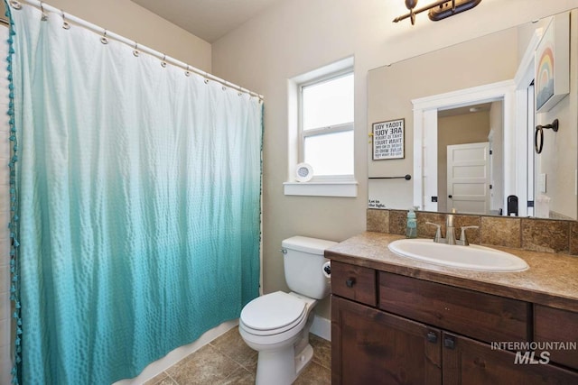 bathroom featuring toilet, vanity, tile patterned floors, and curtained shower