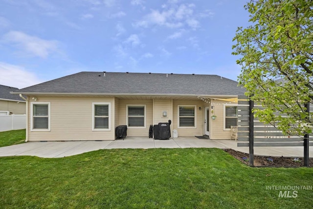 rear view of house with a patio and a shingled roof