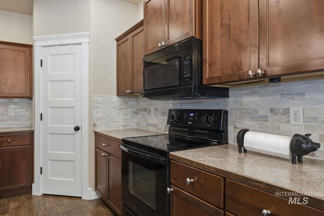 kitchen featuring black appliances, backsplash, and dark wood-type flooring