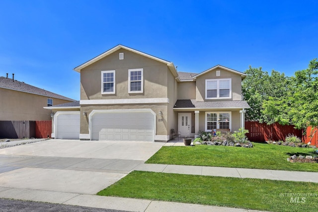 traditional-style house featuring a garage, driveway, and stucco siding