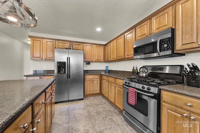 kitchen with stainless steel appliances, brown cabinets, recessed lighting, and a textured ceiling
