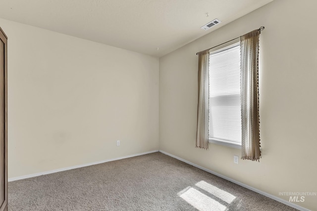 unfurnished room featuring carpet and baseboards