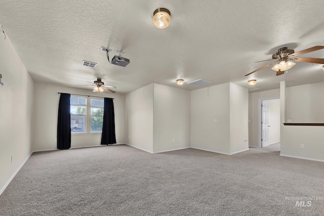 unfurnished room with ceiling fan, a textured ceiling, light carpet, and baseboards