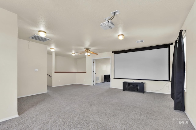 carpeted home theater with ceiling fan and baseboards