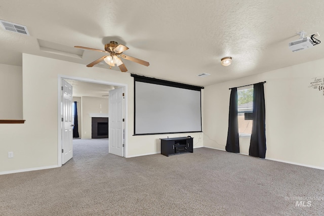 cinema with carpet, ceiling fan, baseboards, a fireplace, and a textured ceiling