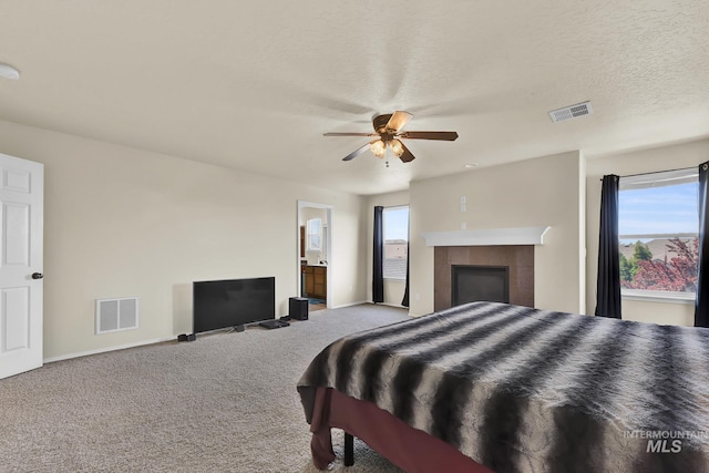 carpeted bedroom with multiple windows, baseboards, a ceiling fan, and a tiled fireplace