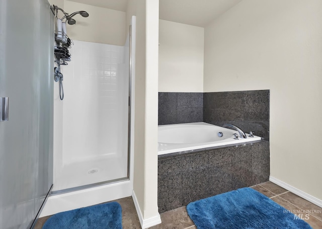 bathroom with a shower stall, a bath, tile patterned flooring, and baseboards