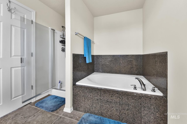 full bath featuring a stall shower, tile patterned flooring, and a garden tub
