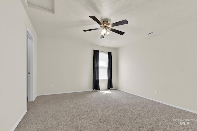 empty room featuring carpet flooring, a textured ceiling, a ceiling fan, and baseboards