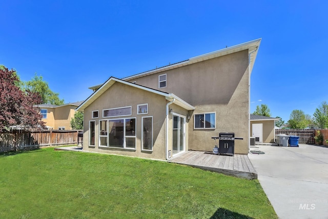 back of house with stucco siding, a wooden deck, and central AC unit