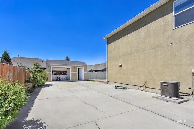 view of home's exterior with fence, stucco siding, cooling unit, and a patio area