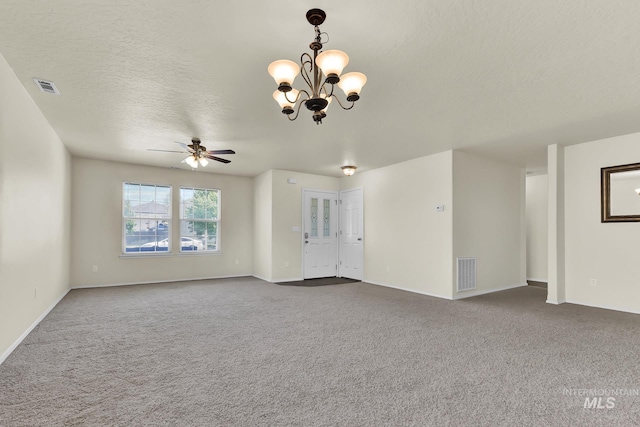 unfurnished living room with dark carpet, ceiling fan, a chandelier, a textured ceiling, and baseboards