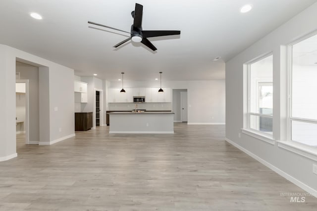 unfurnished living room with recessed lighting, baseboards, light wood-style flooring, and a ceiling fan