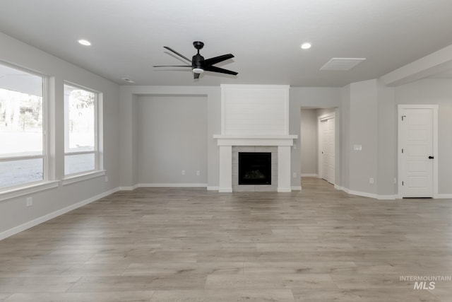 unfurnished living room with recessed lighting, a fireplace, light wood-type flooring, and baseboards