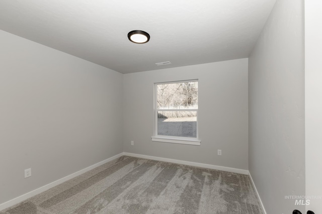 spare room with baseboards, carpet floors, and visible vents