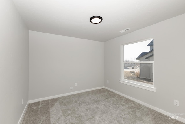 empty room with visible vents, baseboards, and carpet