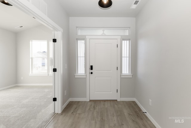 foyer entrance featuring visible vents, a healthy amount of sunlight, and baseboards