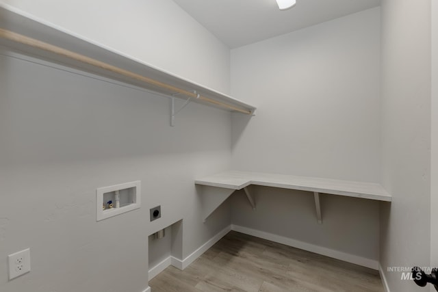 laundry area with electric dryer hookup, light wood-style flooring, baseboards, hookup for a washing machine, and laundry area