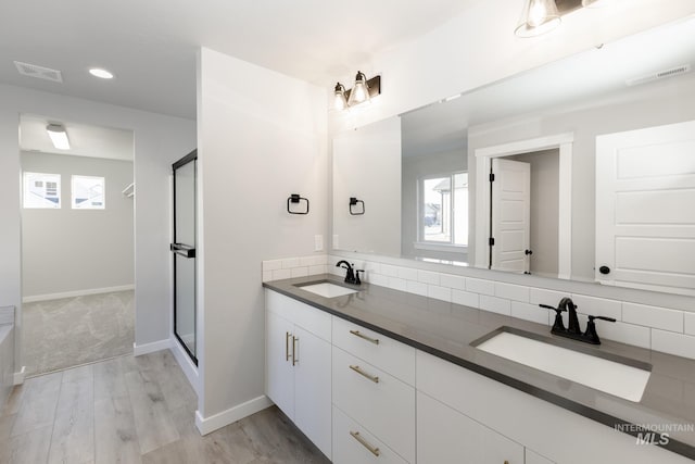 bathroom with visible vents, a shower stall, and a sink