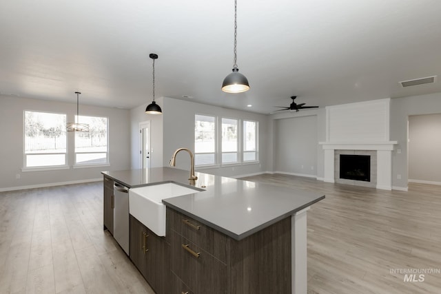 kitchen featuring a sink, visible vents, light wood-style floors, and dishwasher