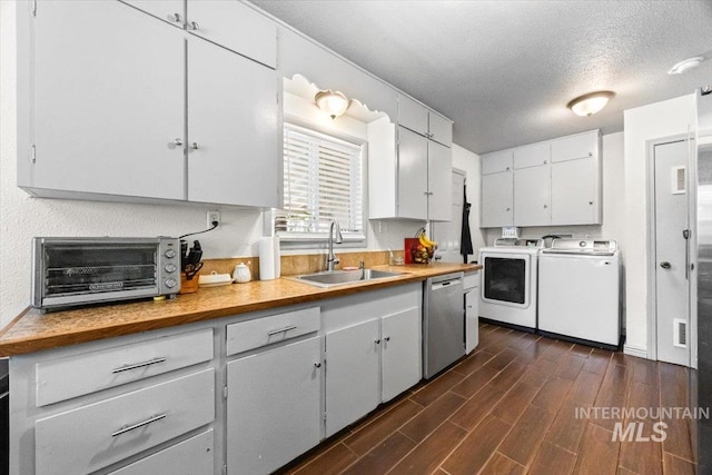 77 S Canyon St, Nampa, ID 83651 - kitchen with independent washer and dryer, stainless steel dishwasher, dark wood finished floors, light countertops, and white cabinets