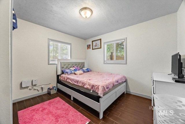 77 S Canyon St, Nampa, ID 83651 - bedroom featuring multiple windows, dark wood-type flooring, and a textured ceiling