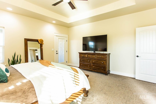 bedroom with ceiling fan and a raised ceiling