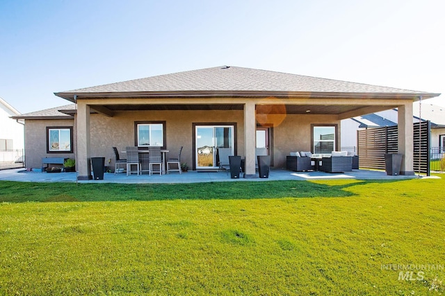 back of property with an outdoor living space, a lawn, and a patio area