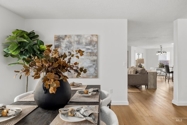 interior space featuring baseboards, an inviting chandelier, and wood finished floors