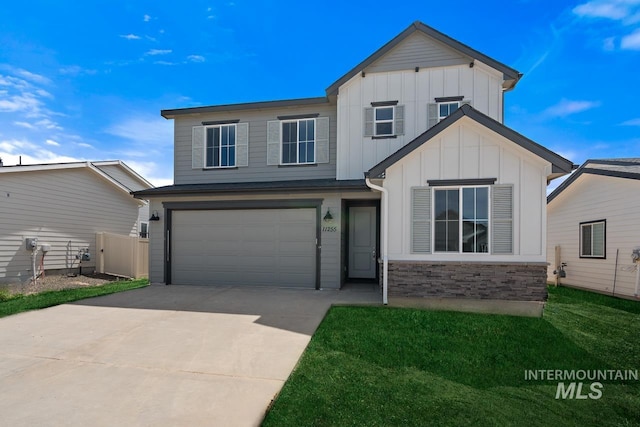 view of front of property with stone siding, fence, board and batten siding, concrete driveway, and a garage