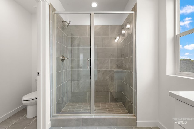 full bath with a shower stall, toilet, baseboards, and tile patterned floors