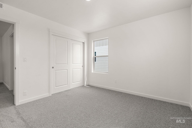 unfurnished bedroom featuring carpet floors, visible vents, and baseboards