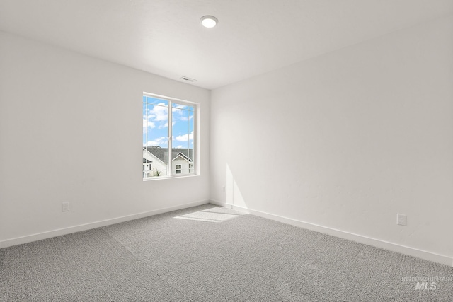 carpeted empty room featuring visible vents and baseboards