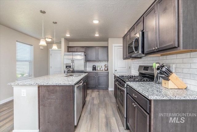 17719 Jackson Ridge Way, Nampa, ID 83687 - kitchen featuring appliances with stainless steel finishes, a sink, dark brown cabinets, wood finished floors, and a textured ceiling