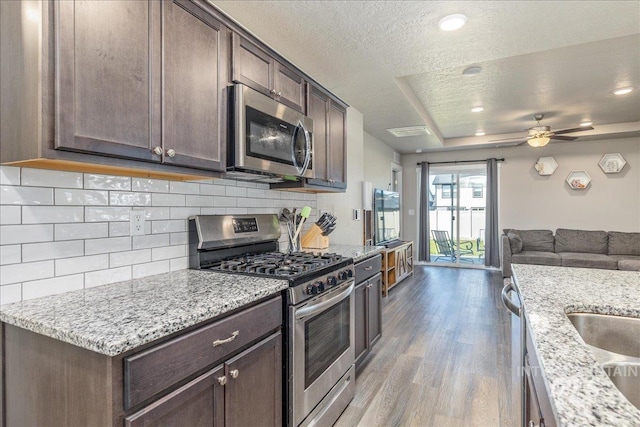 17719 Jackson Ridge Way, Nampa, ID 83687 - kitchen featuring stainless steel appliances, wood finished floors, dark brown cabinetry, a textured ceiling, and open floor plan
