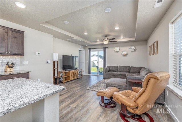 17719 Jackson Ridge Way, Nampa, ID 83687 - living area with a tray ceiling, light wood finished floors, plenty of natural light, ceiling fan, and recessed lighting