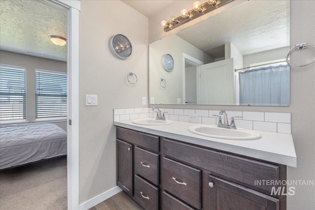17719 Jackson Ridge Way, Nampa, ID 83687 - bathroom featuring decorative backsplash, double vanity, baseboards, and a textured ceiling