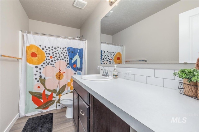 17719 Jackson Ridge Way, Nampa, ID 83687 - full bath featuring wood finished floors, toilet, vanity, baseboards, and a textured ceiling