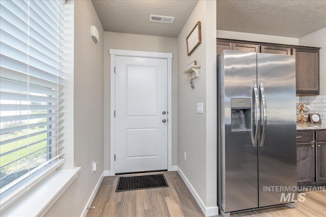 17719 Jackson Ridge Way, Nampa, ID 83687 - entryway featuring light wood-style flooring, a textured ceiling, and baseboards