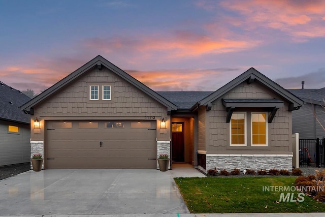 craftsman house with stone siding, concrete driveway, a garage, and fence