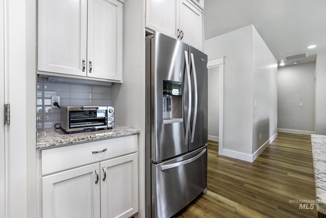 kitchen with stainless steel fridge with ice dispenser, white cabinetry, visible vents, dark wood-style flooring, and backsplash