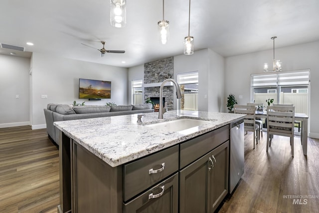 kitchen with ceiling fan with notable chandelier, dark wood finished floors, visible vents, dishwasher, and a sink