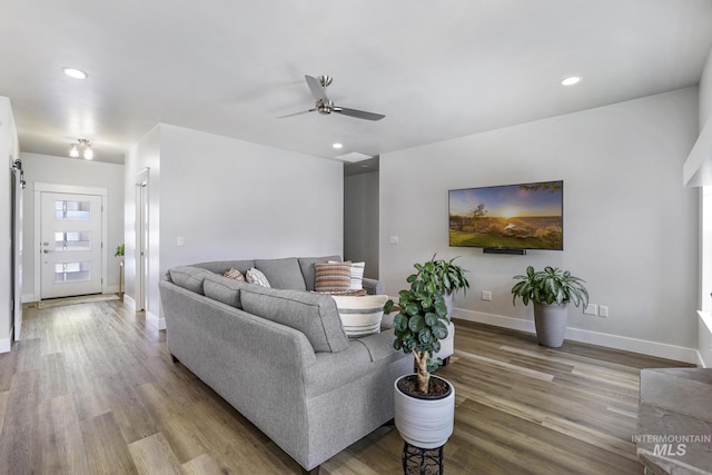 living area with ceiling fan, recessed lighting, wood finished floors, and baseboards