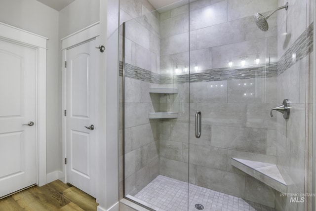 bathroom featuring a stall shower and wood finished floors