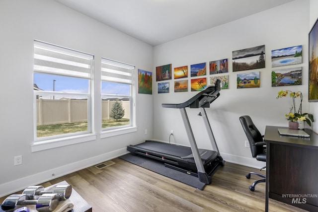workout room with visible vents, baseboards, and wood finished floors
