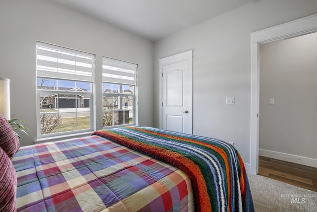 bedroom with baseboards and wood finished floors