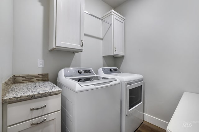 laundry area with independent washer and dryer, baseboards, and cabinet space