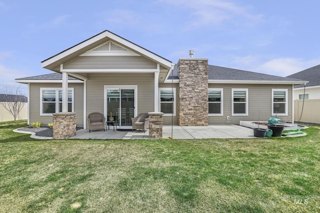 rear view of property featuring a patio, a chimney, a lawn, fence, and a shingled roof