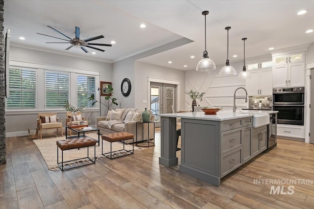 kitchen featuring stainless steel appliances, gray cabinets, a sink, a ceiling fan, and light countertops