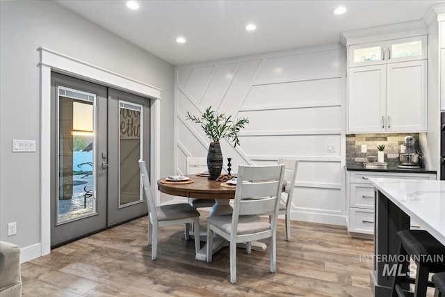 dining room with recessed lighting, light wood-style flooring, and french doors
